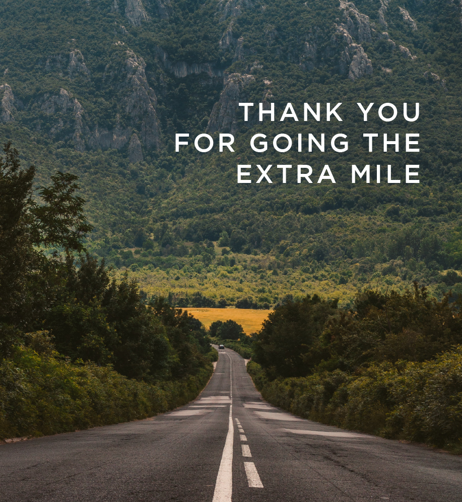 Scenic road through the mountains. Text: Thank you for going the extra mile.