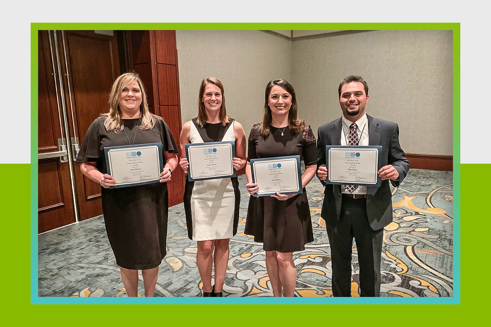 four people holding certificates and smiling at camera
