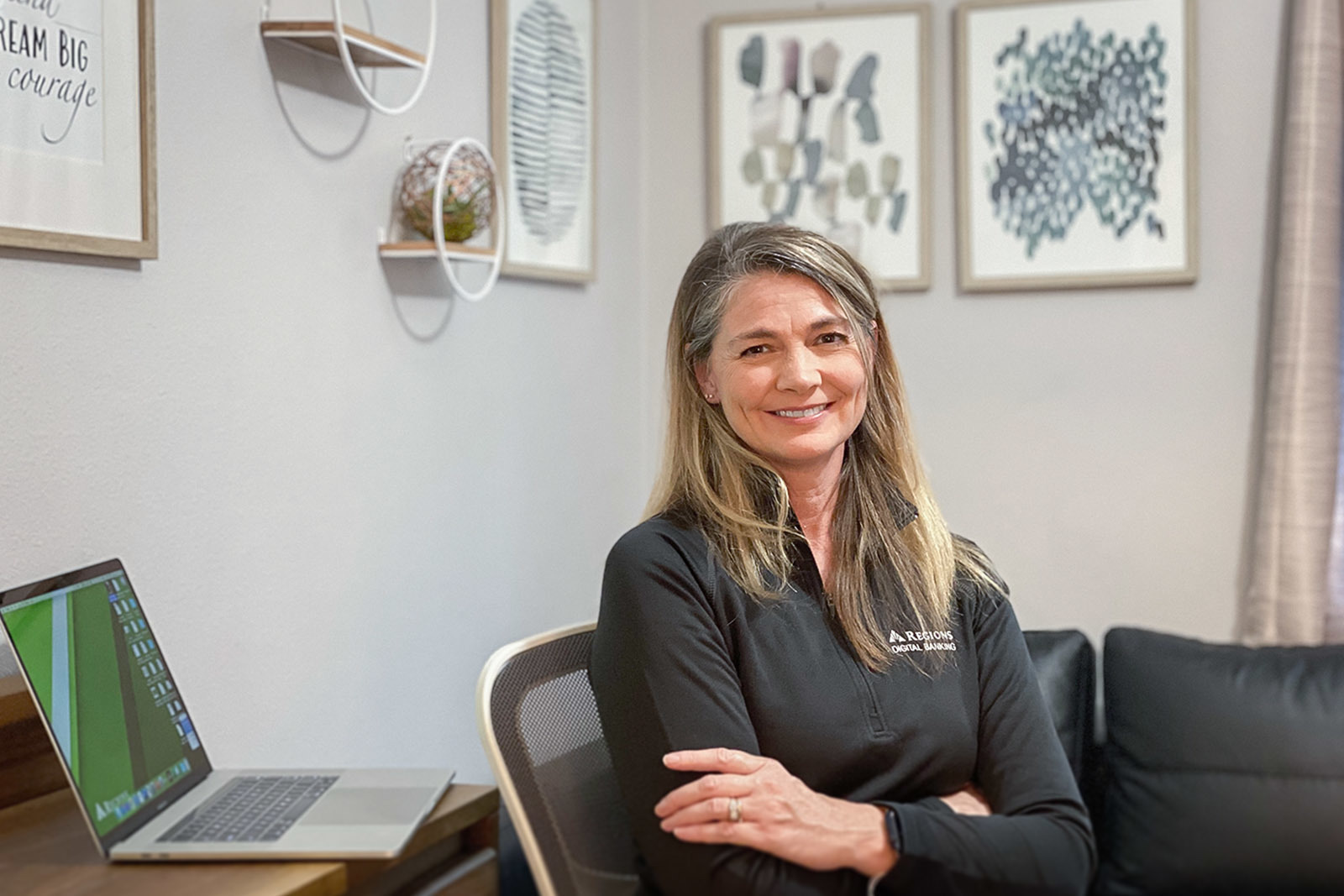 a woman seated at desk and smiling at camera