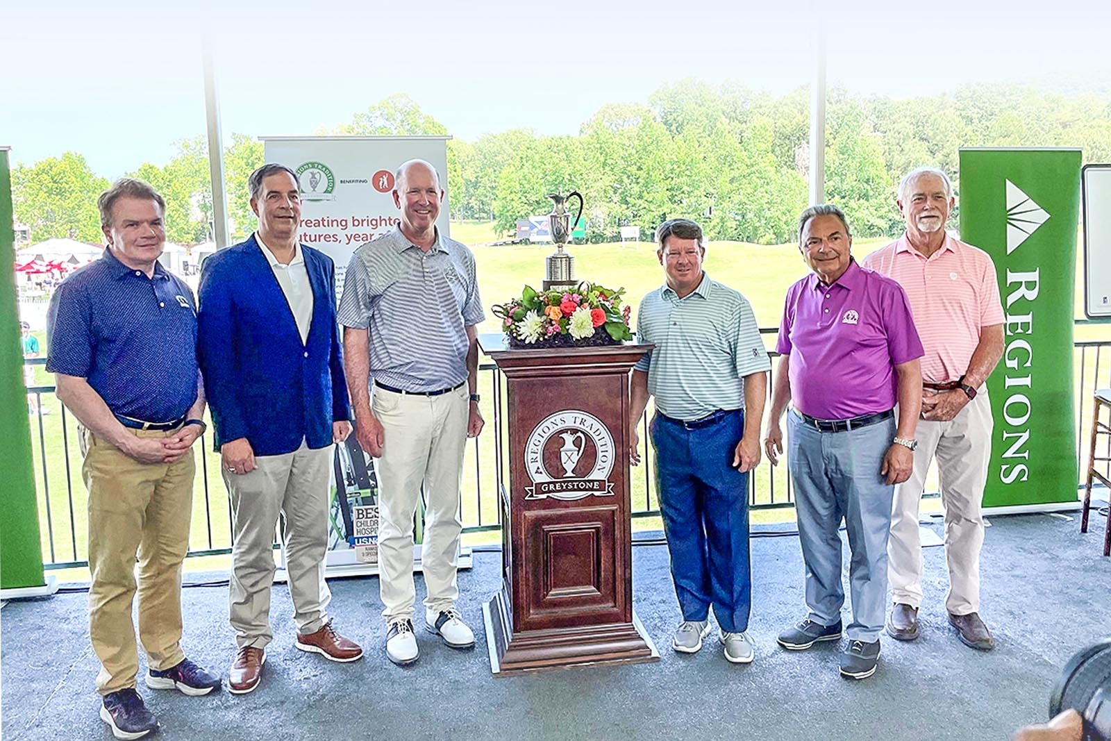 Group of people smiling for camera at Regions Tradition event,