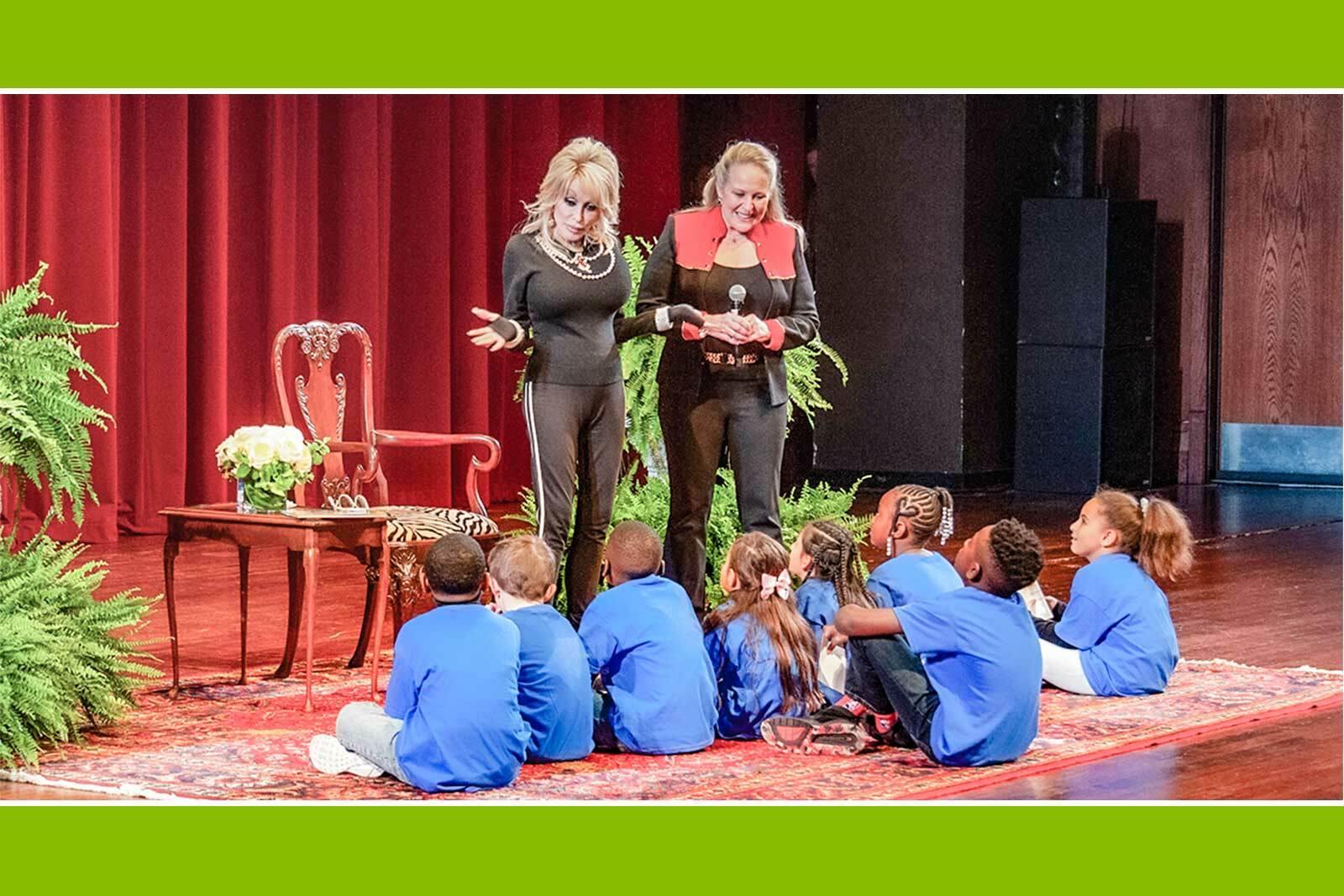 Dolly Parton on stage greeting a group of children