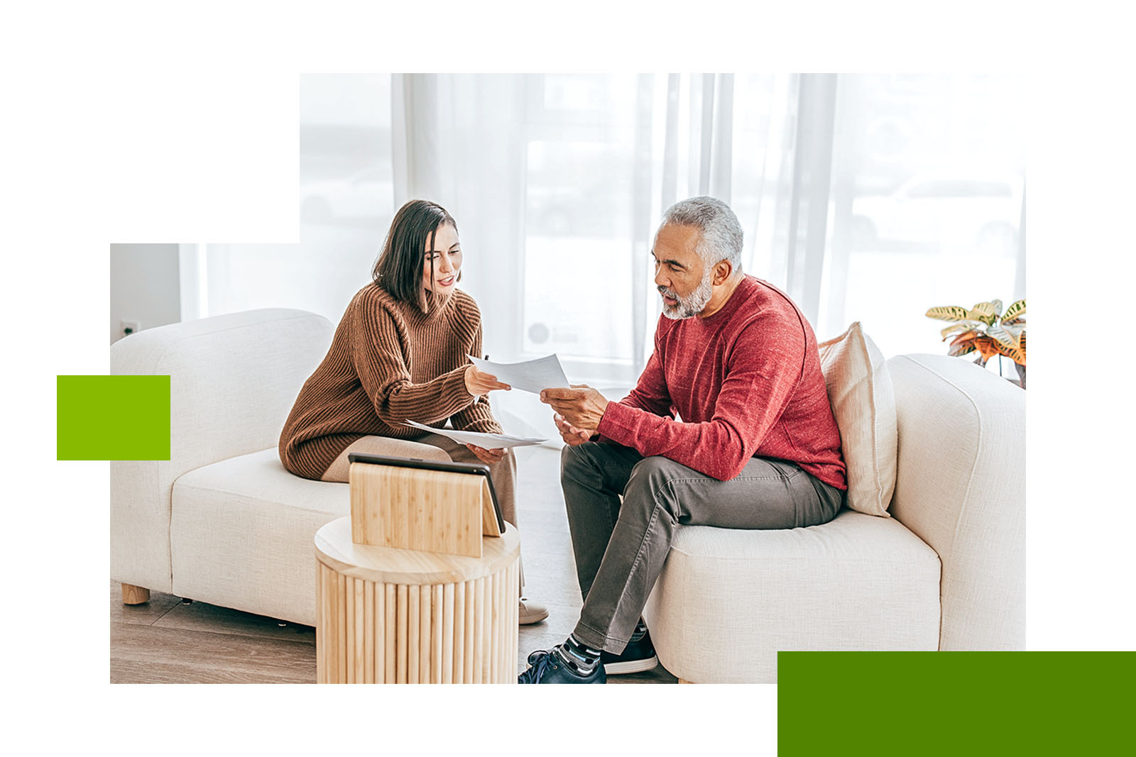 a young and older person reviewing documents on a couch
