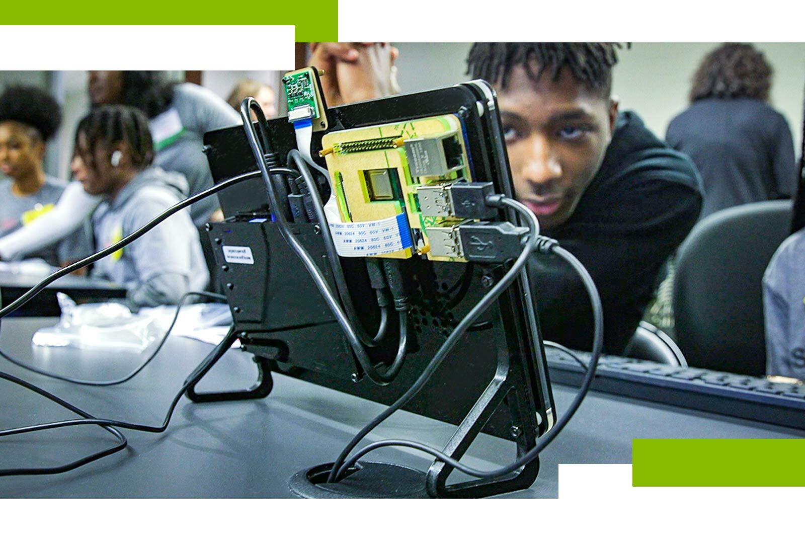 closeup photo of a Raspberry Pi, with students in the...