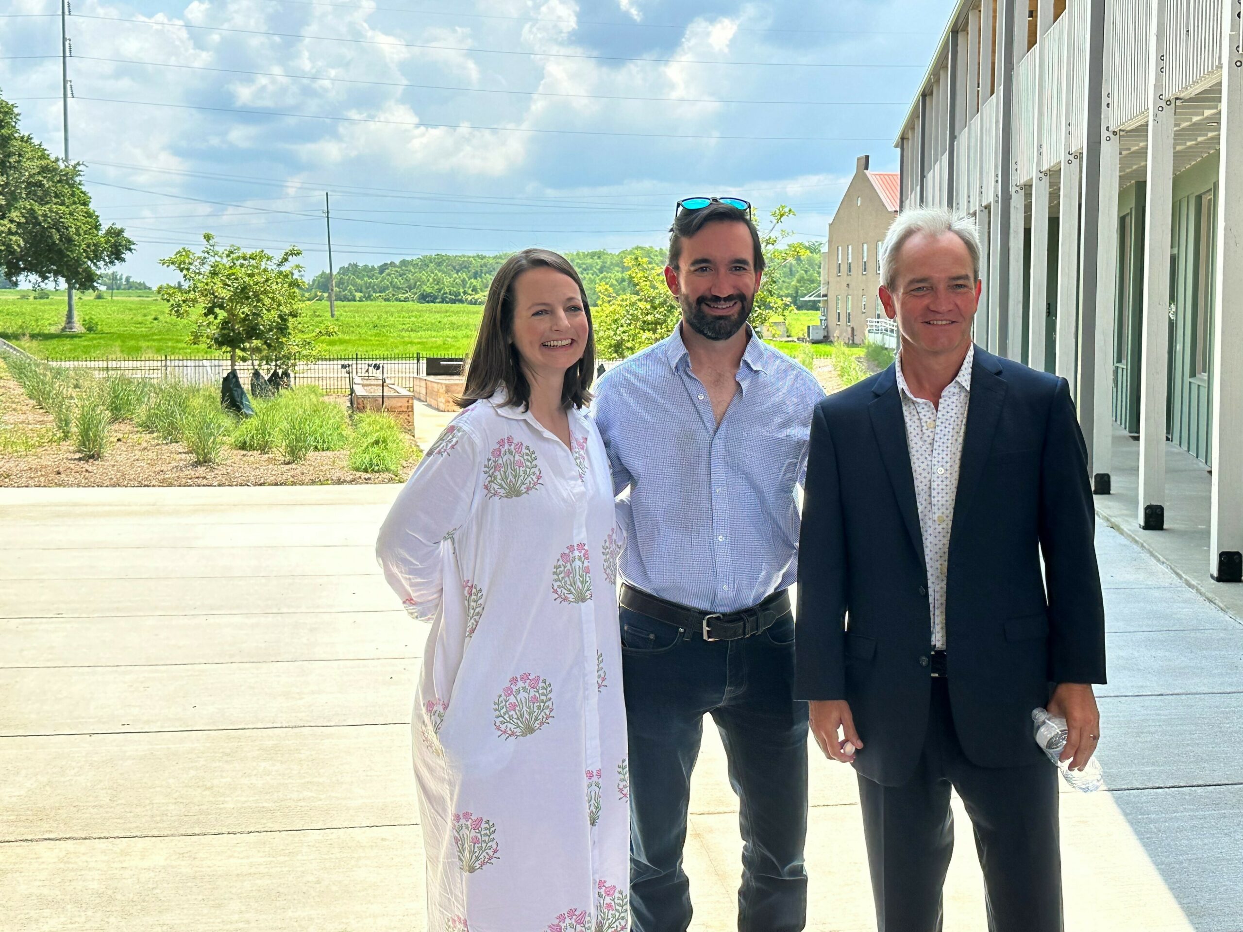 group of three people standing outdoors at the apartment complex