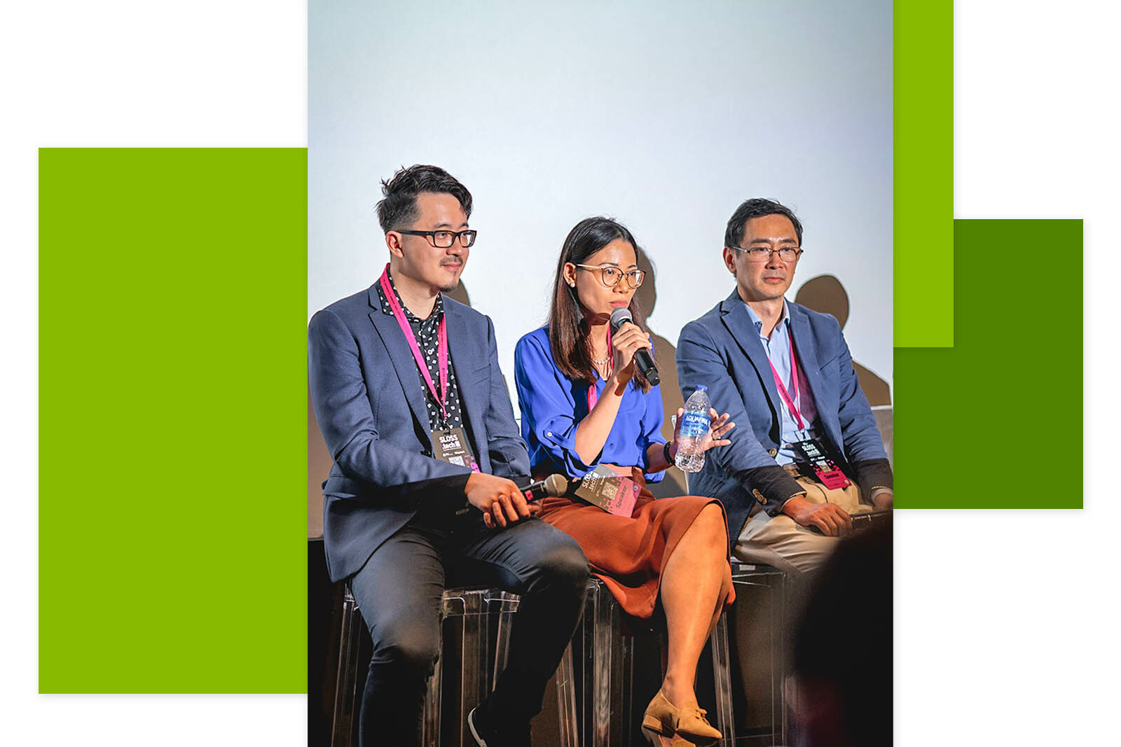 Three people are sitting at the event, the middle one is asking a question