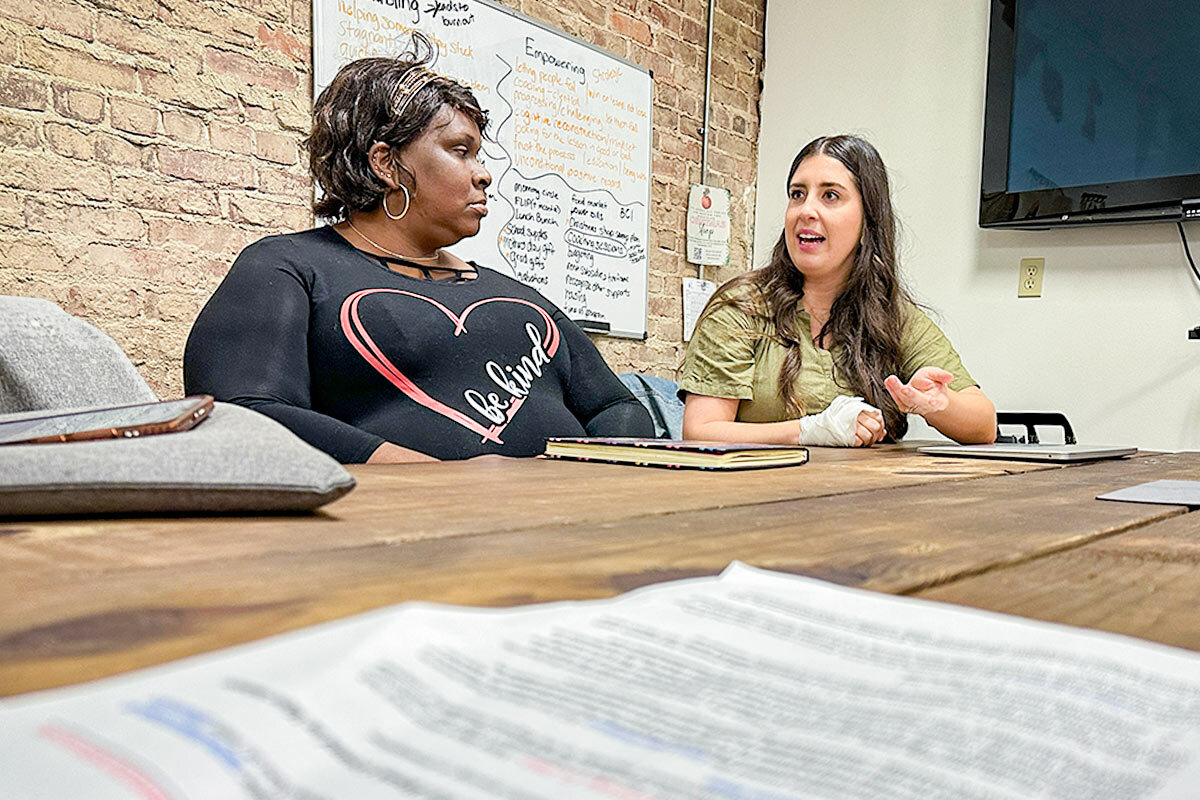 Two women sitting at a conference table discussing the build project.