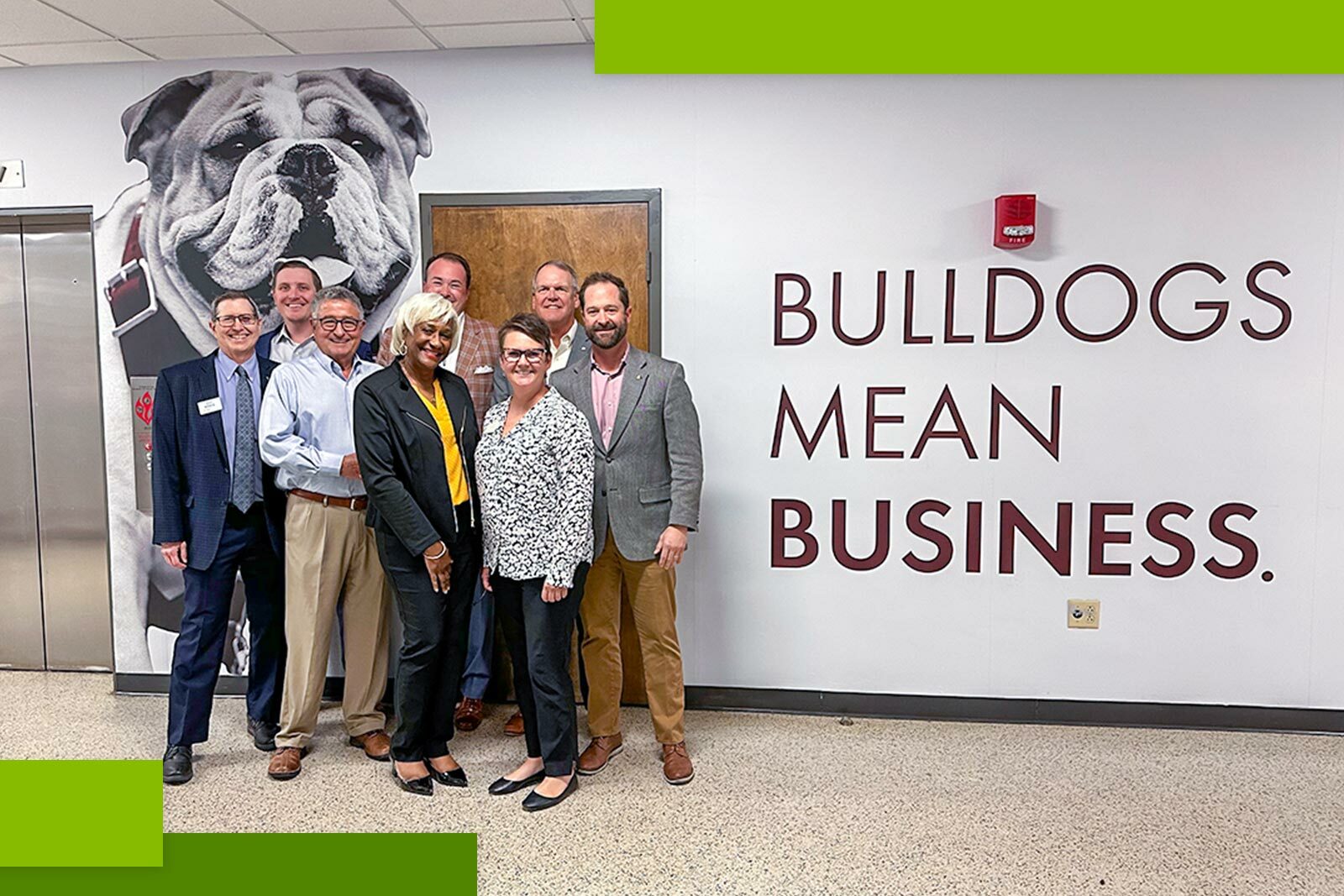 Group of people next to the wall with words Bulldogs Mean Business