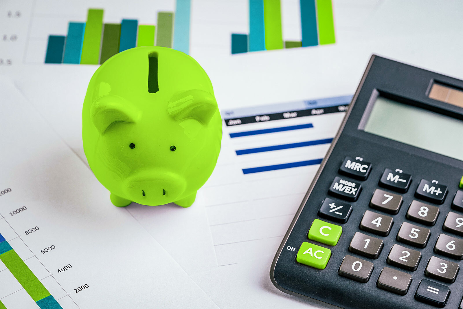 photo of a green piggy bank and calculator on top...