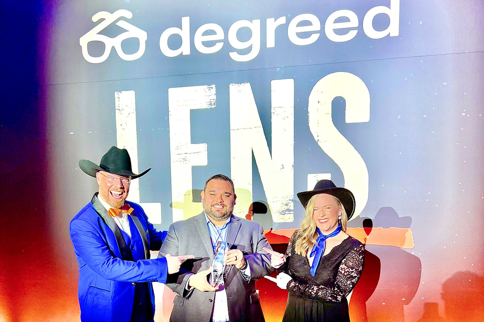 Three Regions associates holding Degreed Award on stage.
