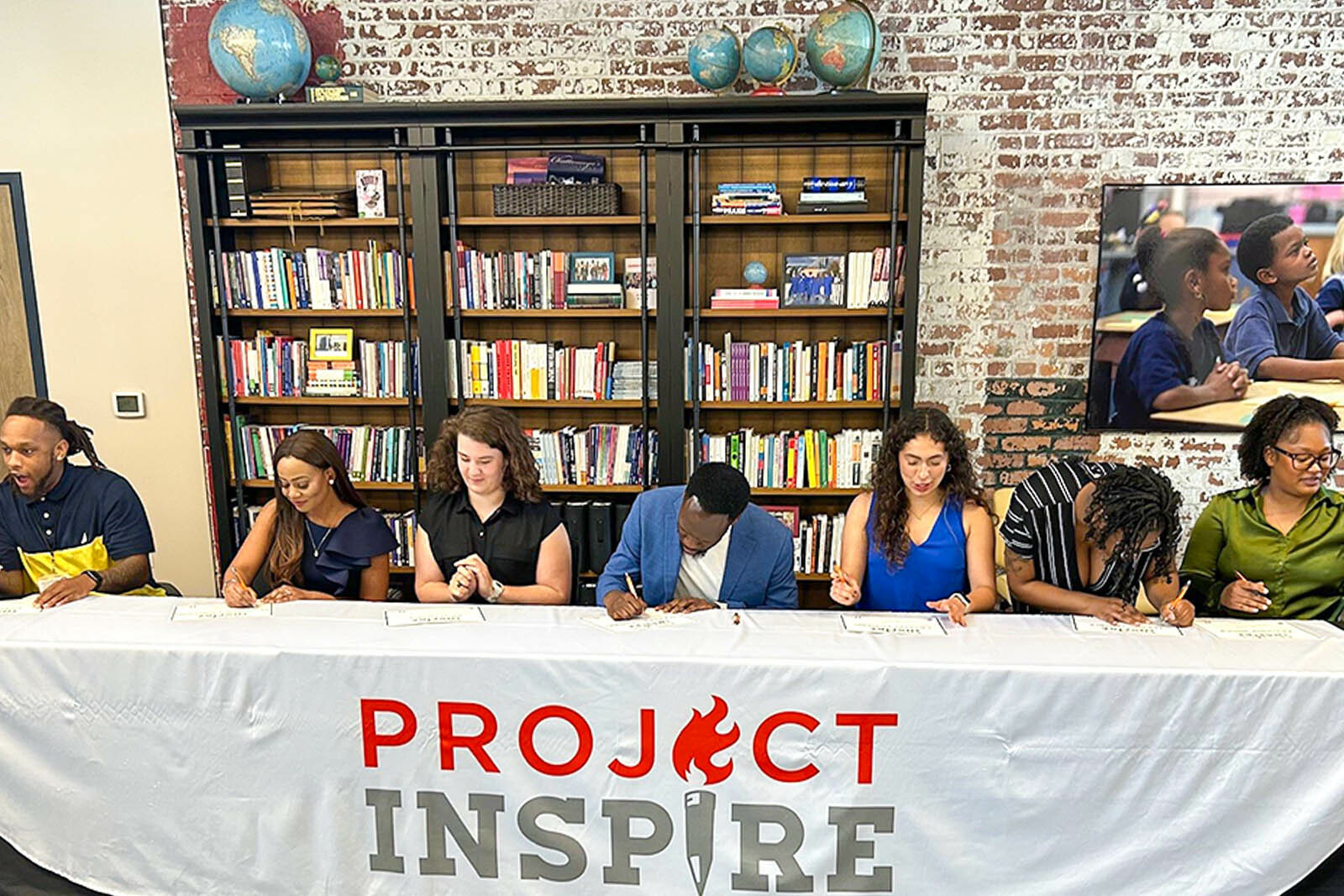 people signing on table at Project Inspire event