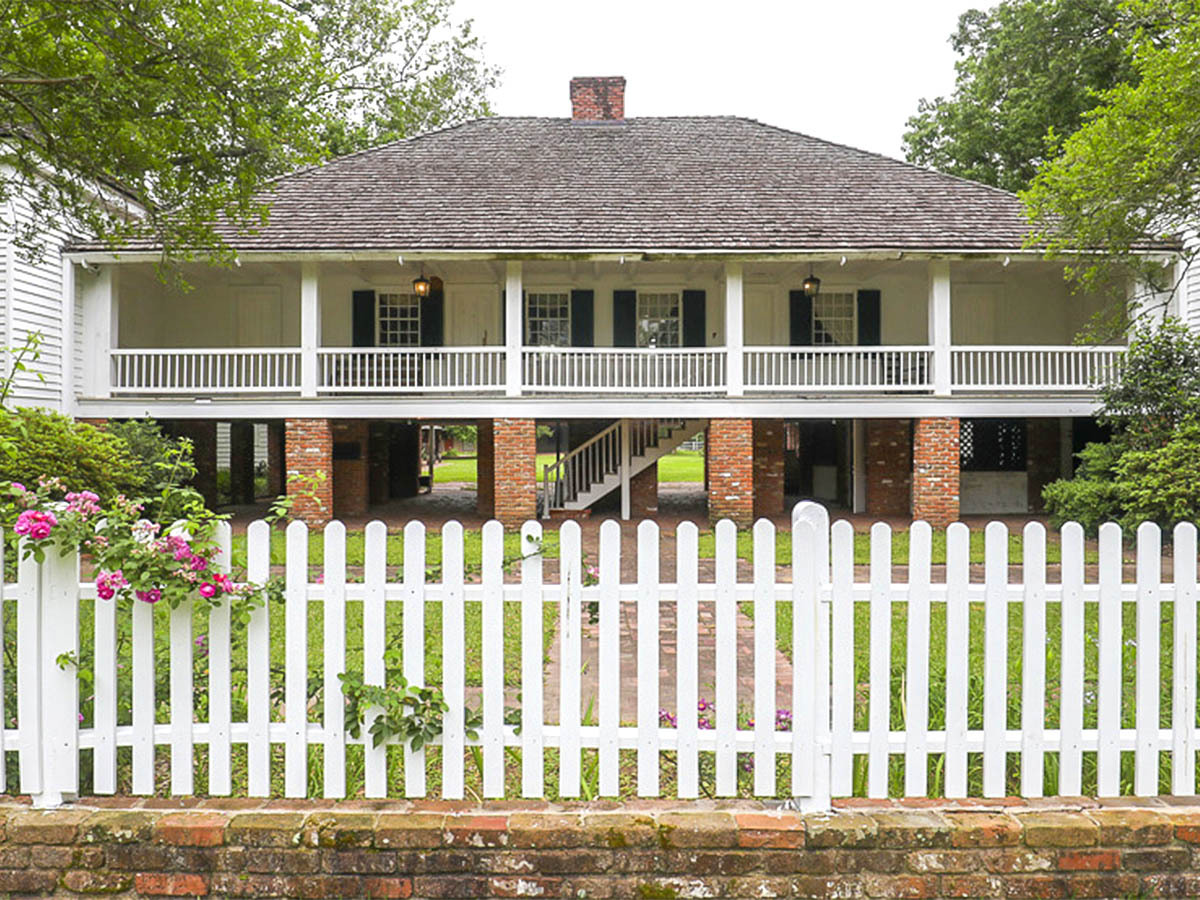 A white picket fence surrounds the front yard of the famous Kent House.