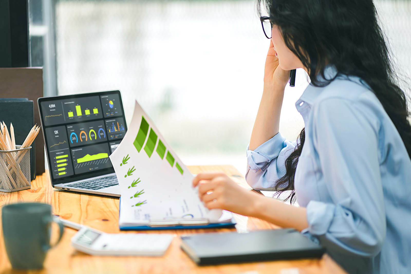Women at the desk looking at financial graph on laptop...