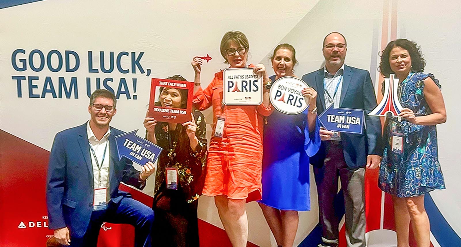 Group of Regions associates smiling in front of the 2024 Olympic sign