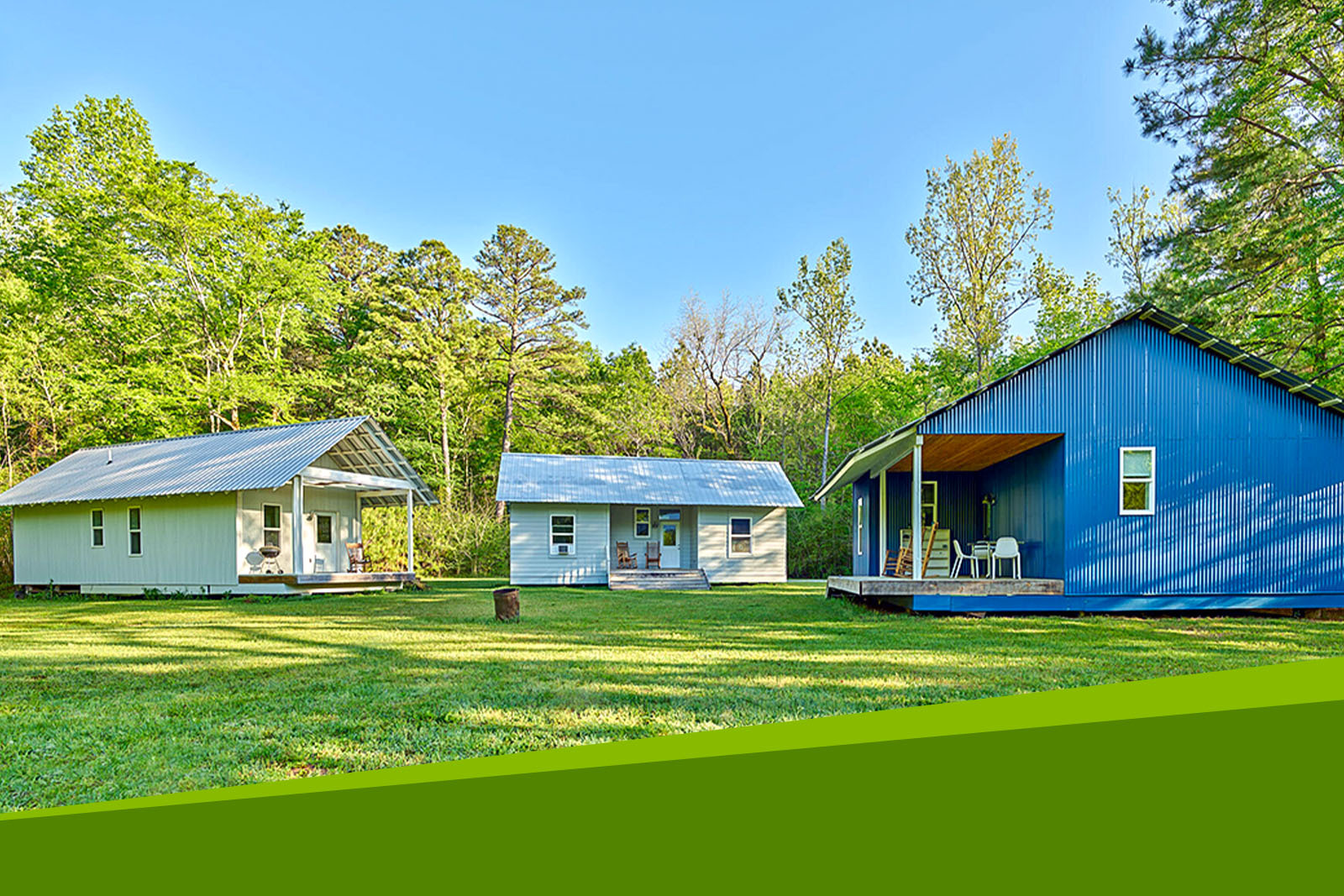 Rural Studio Homes. Three small homes in a grassy field...
