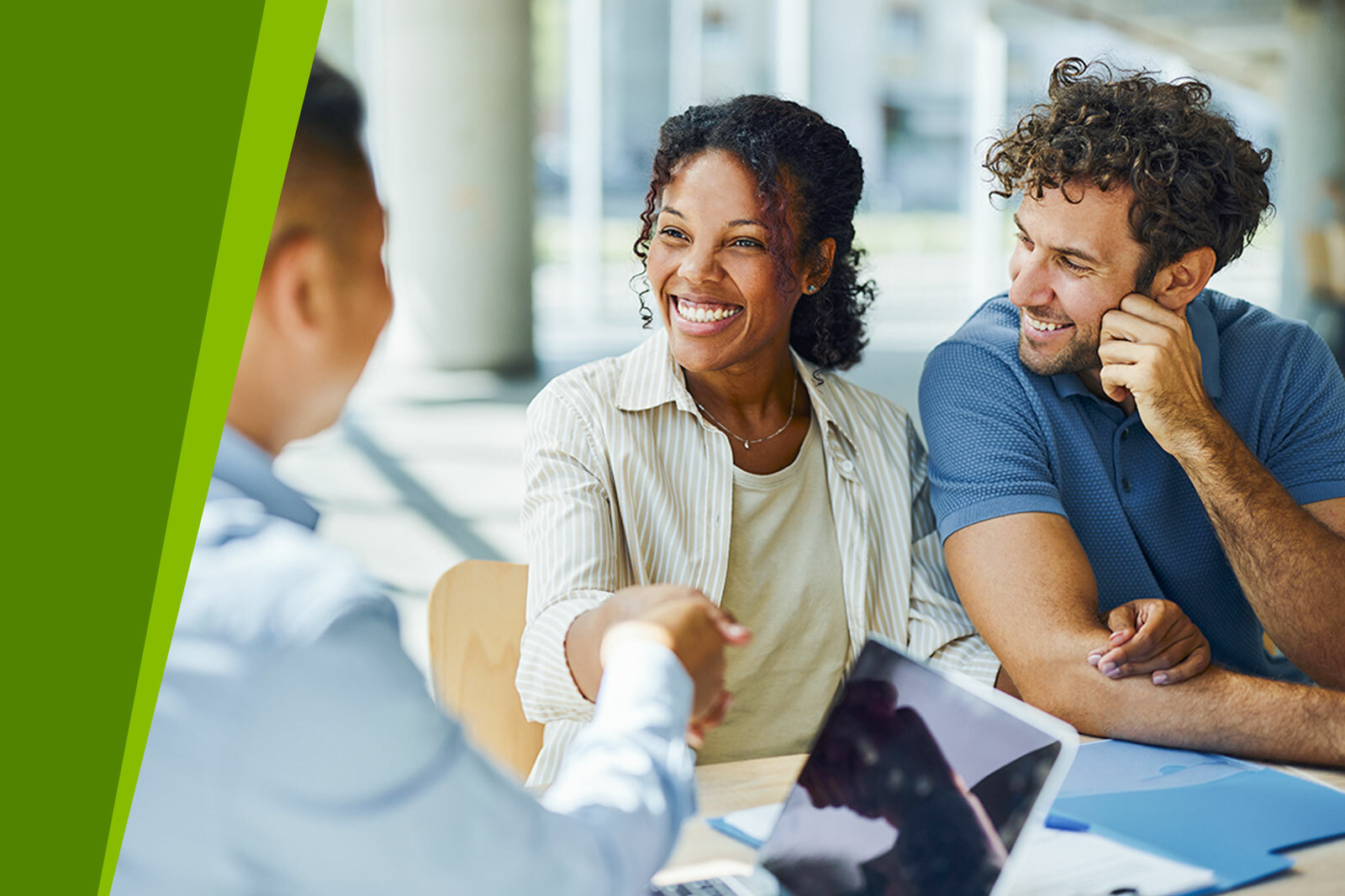 Three people siting in the office, talking, two people shaking...