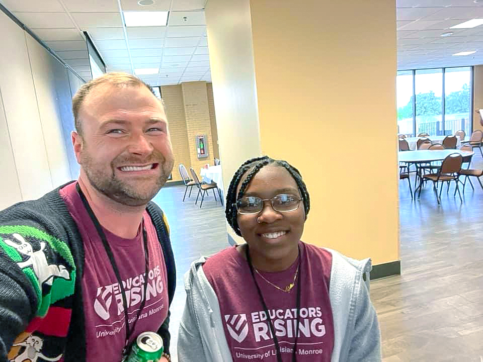 Two smiling individuals taking a selfie photo.