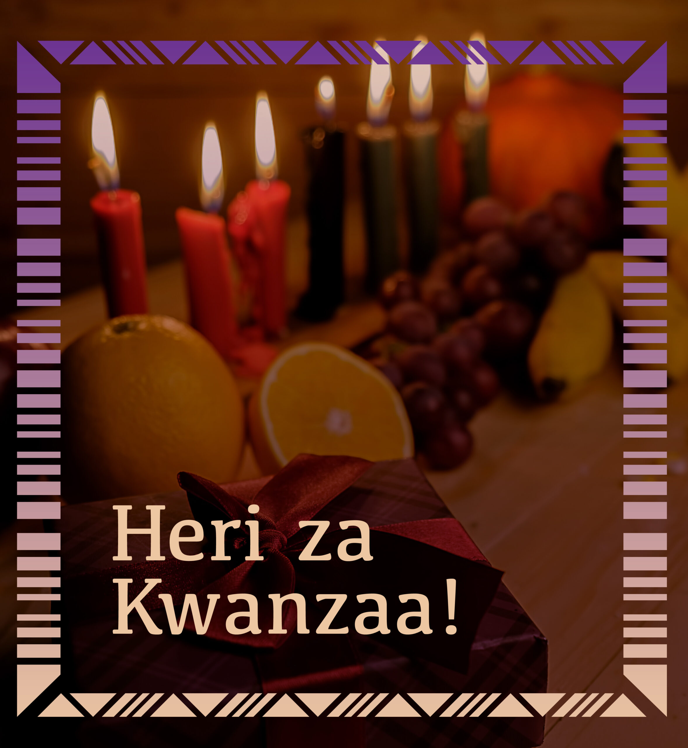 Kwanzaa table with kinara, gift and fruit. Text: Heri za Kwanzaa!