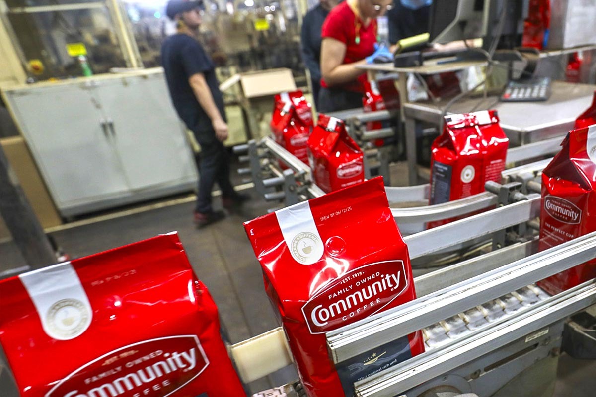 A conveyor belt carries fresh bags of Community Coffee to the next destination.