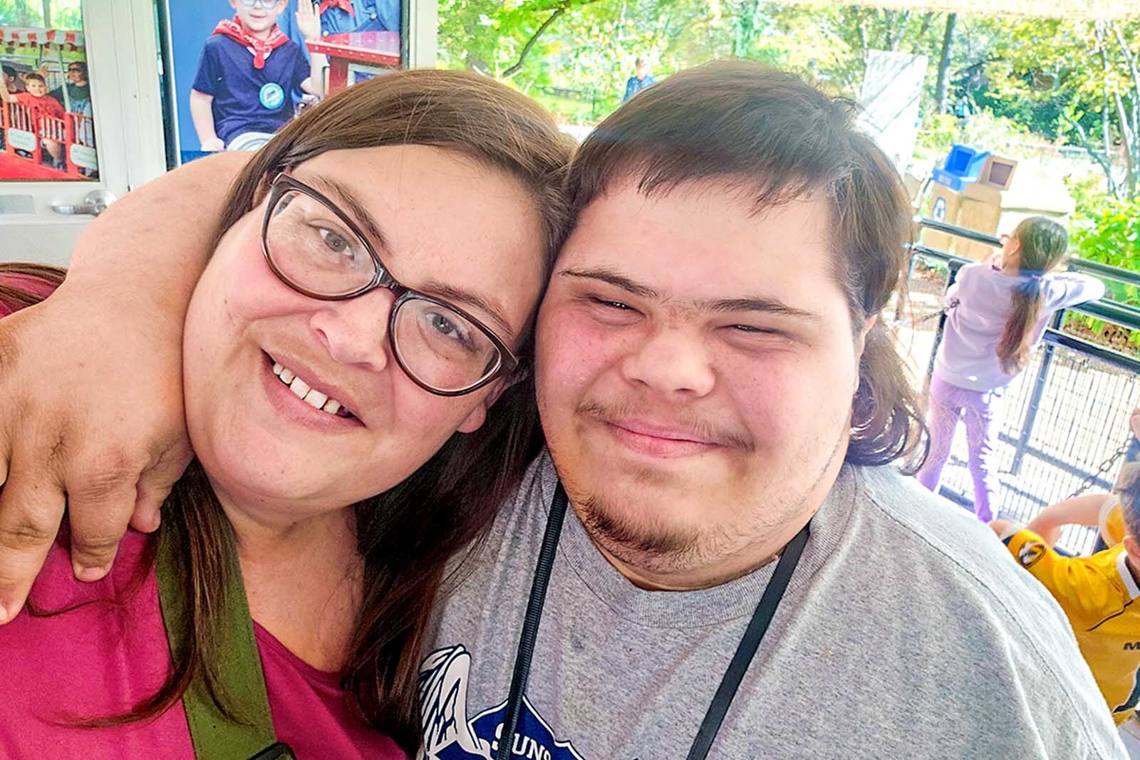 Martha Burkett with her son DJ smiling at the camera outside.