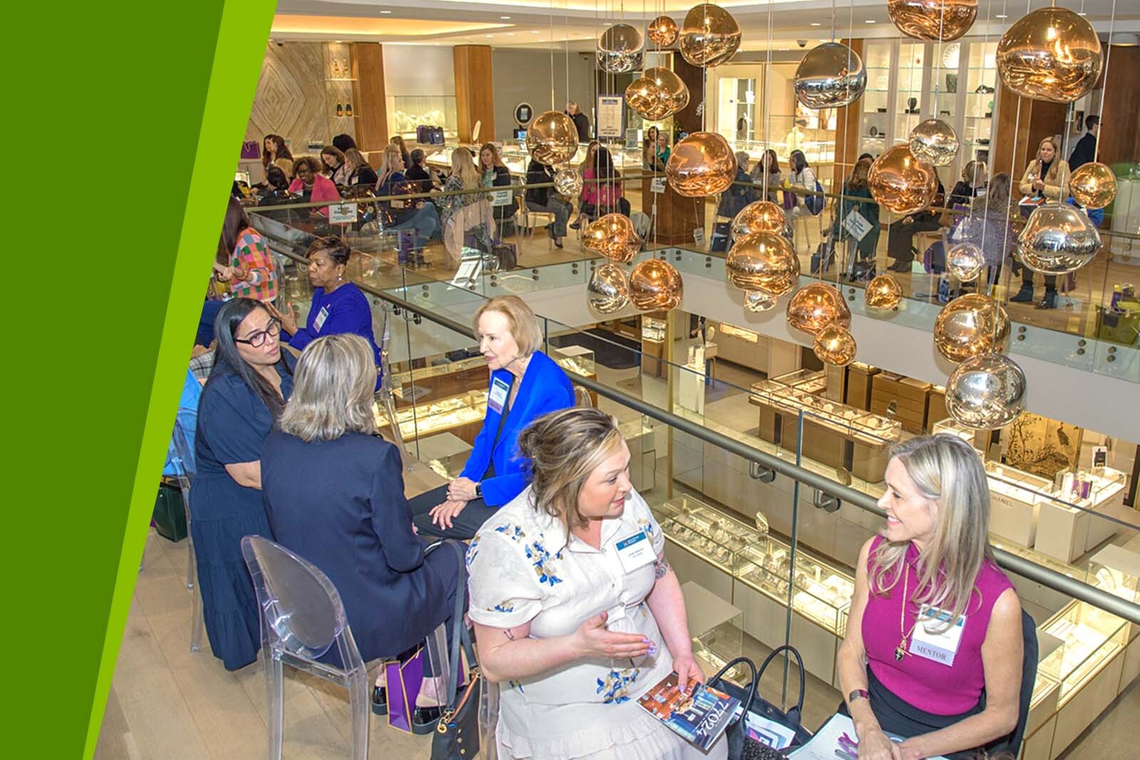 Group of female professionals sitting in a large room having...