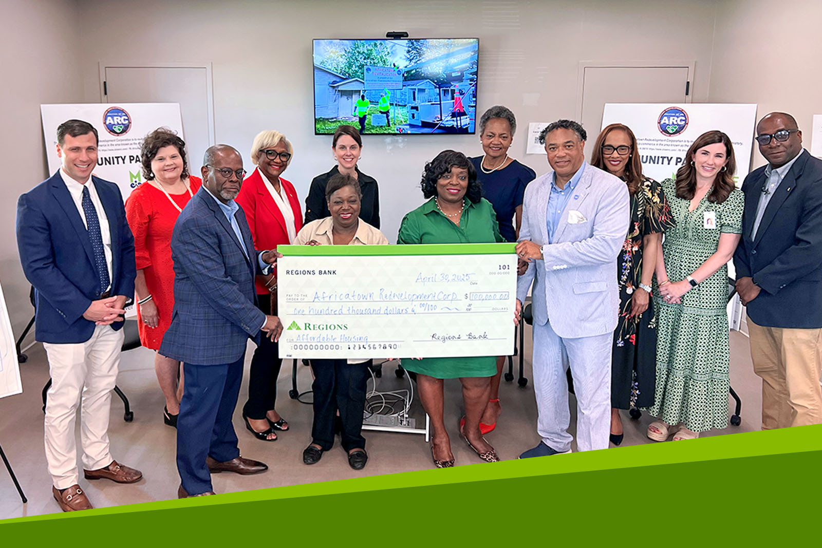 Regions associates and Africatown Redevelopment Corporation (ARC) members holding large...