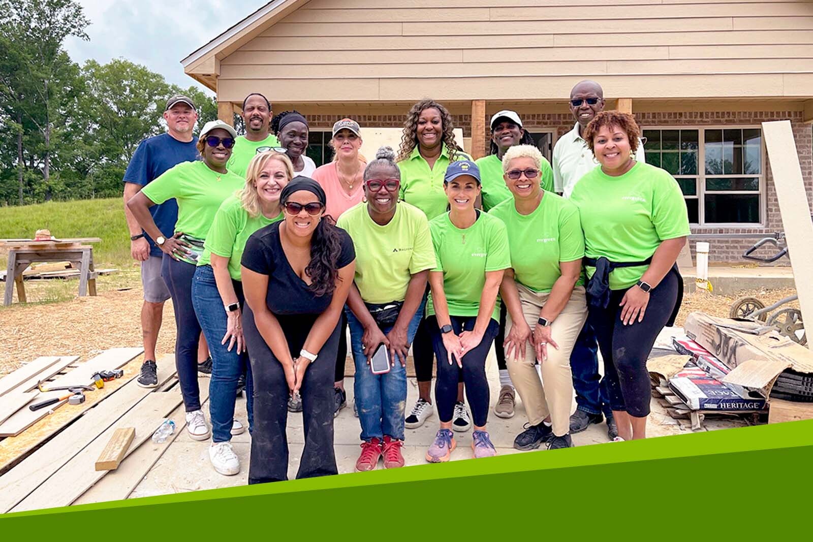 Compliance team group photo in front of a Habitat for...