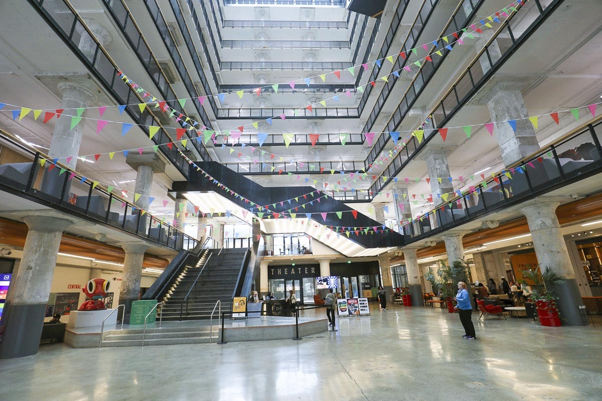Light floods the atrium of the Crosstown Concourse showing off stairs, balconies and levels soaring into the Memphis sky.