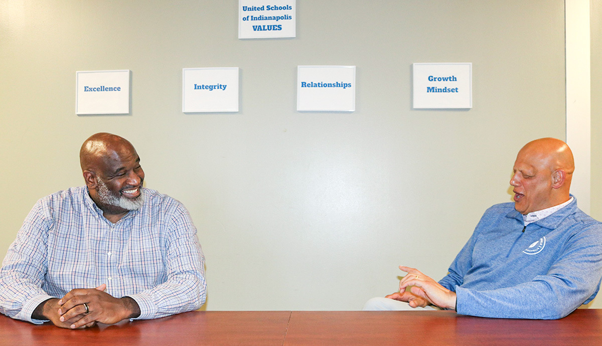 Darius Adamson, superintendent of United Schools of Indianapolis (USI) and Bill Harris, Regions Commercial Banking relationship manager seated at a table having a conversation.