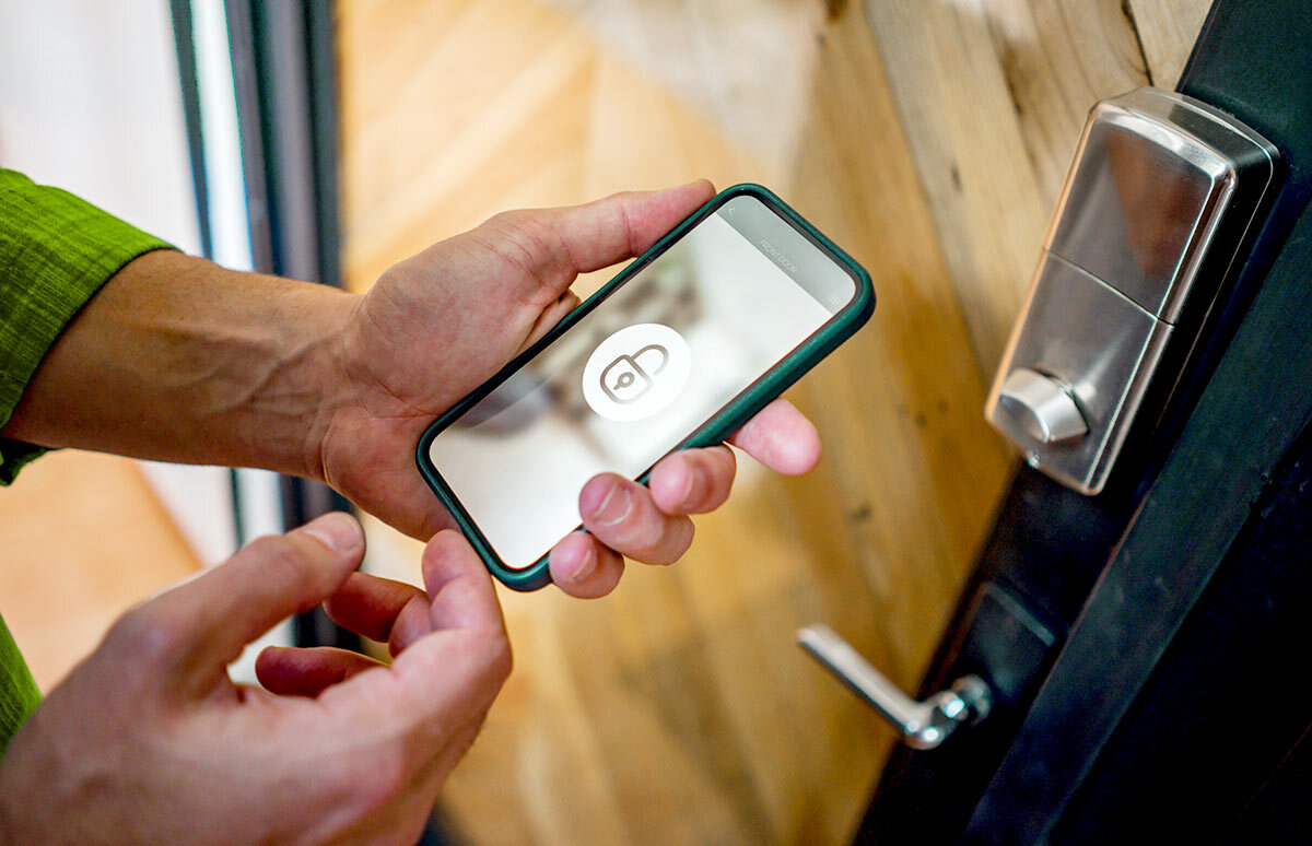 Man opening the door of his house using a home automation system.