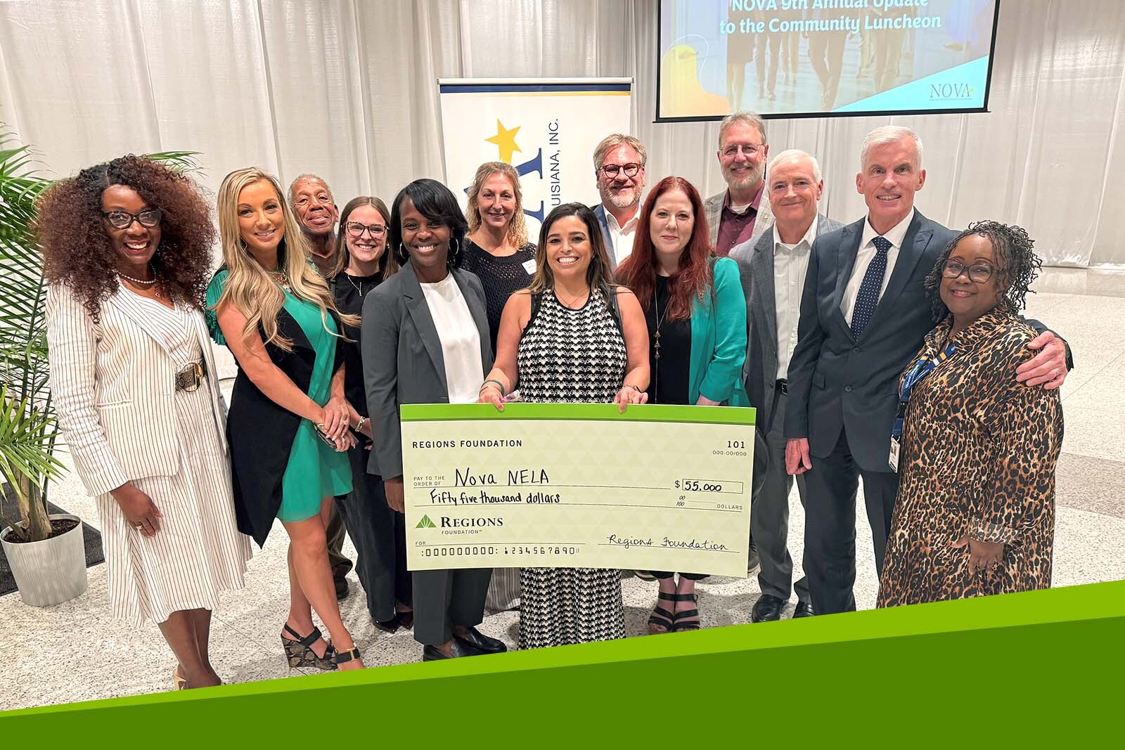 Group photo surrounding a giant check presentation.