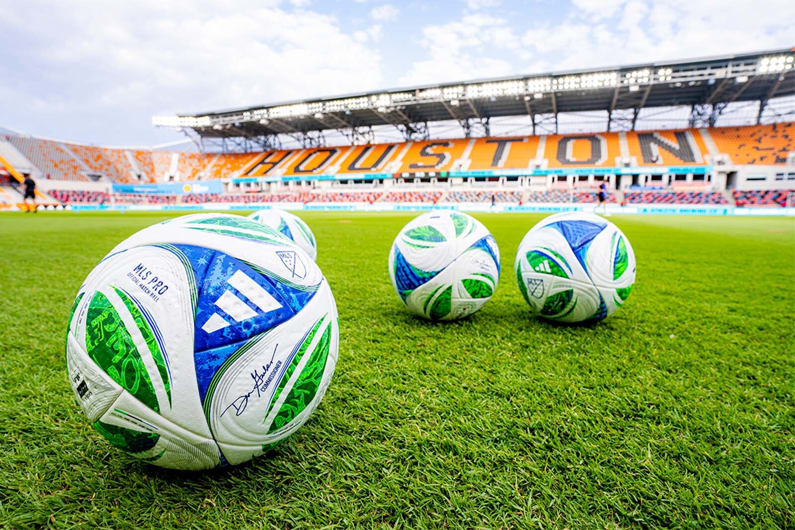 Three soccar balls on the Houston Dynamo and Dash field.