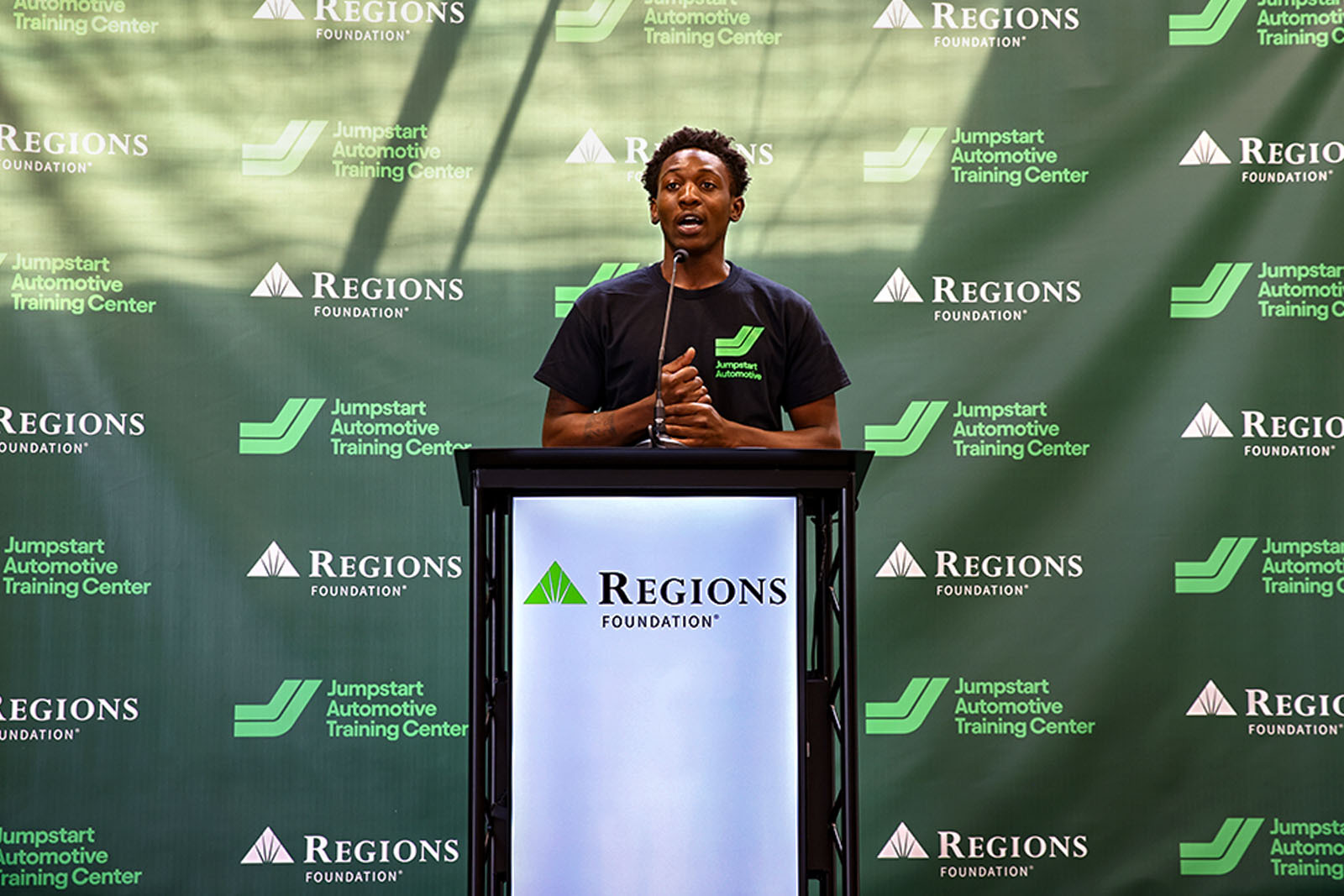 Nicholas Hill, a Jumpstart Alum speaking behind podium.