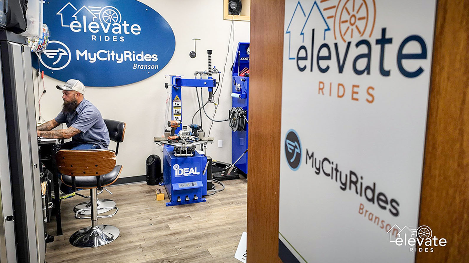 Ryan Fain working in Elevate Rides office with mechanical tools in the background.
