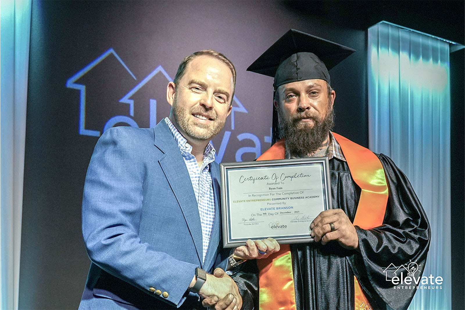 Chris Hunter and Ryan Fain shaking hands at graduation ceremony.