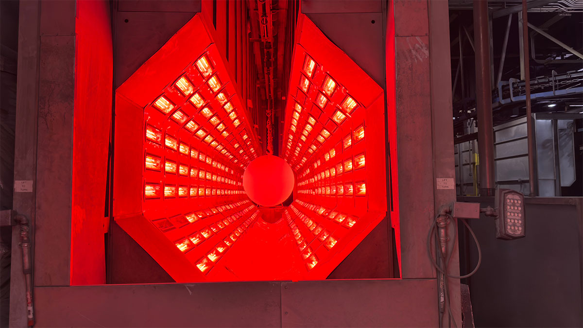 Glowing red machinery inside the factory. 