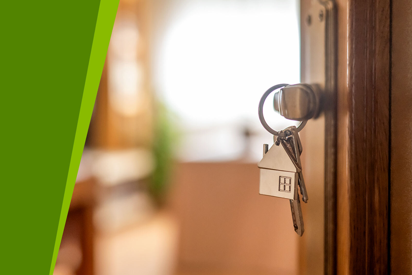 House-shaped keys are hanging from the door knob of a...